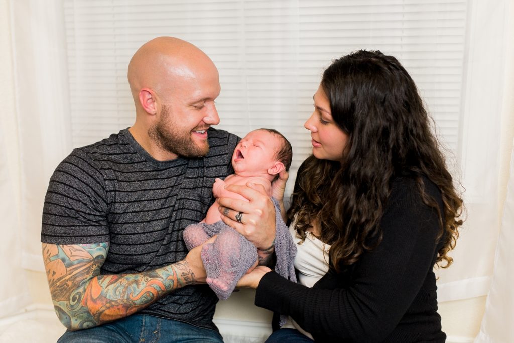 Family of three soothes new baby