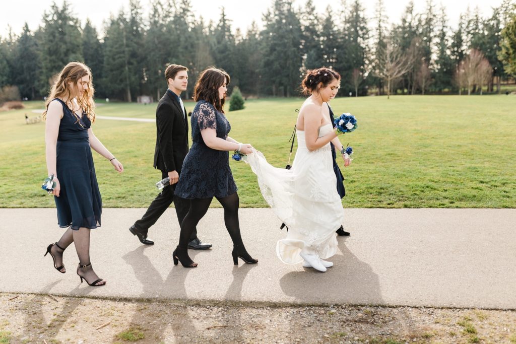 bridesmaids and bride walking along park pathway