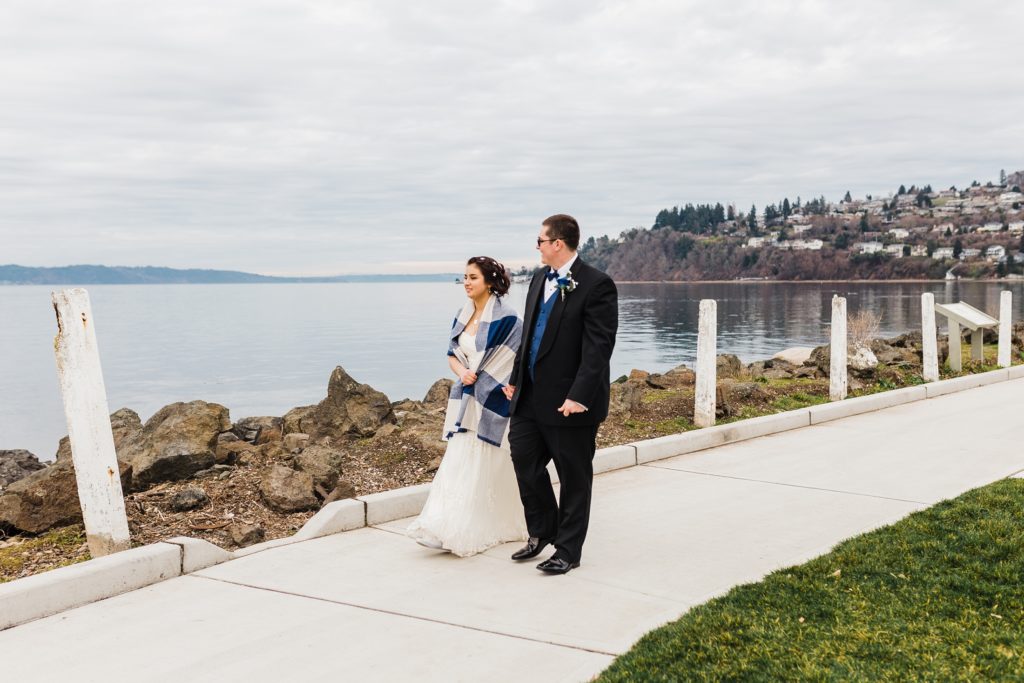 bride and groom walk along white cement pathway