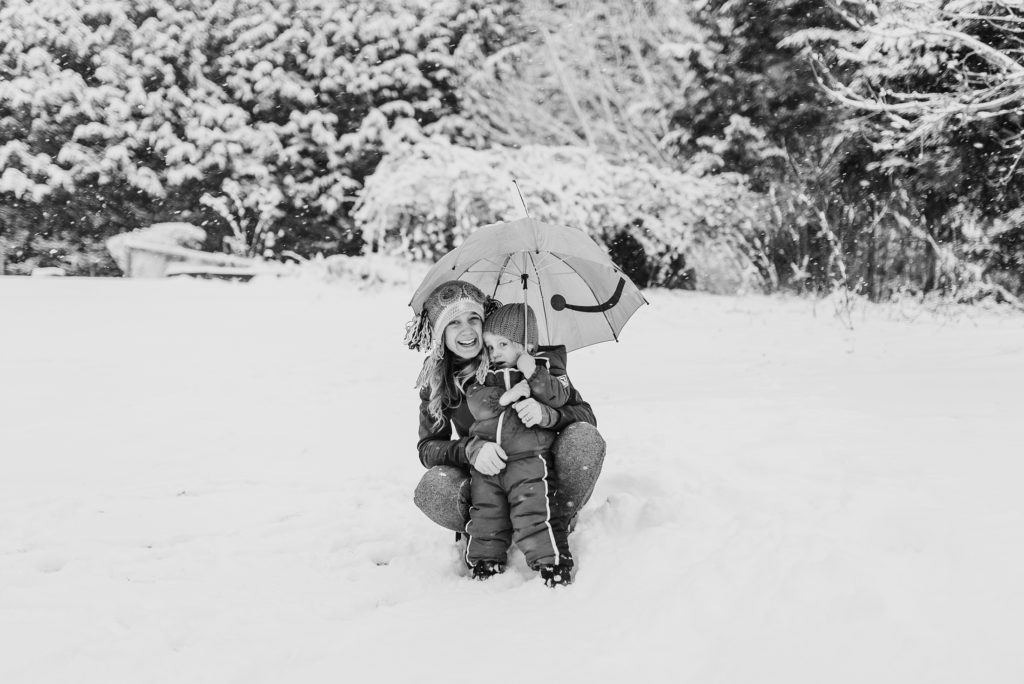 far away photo of mom and son showing woodsy backyard