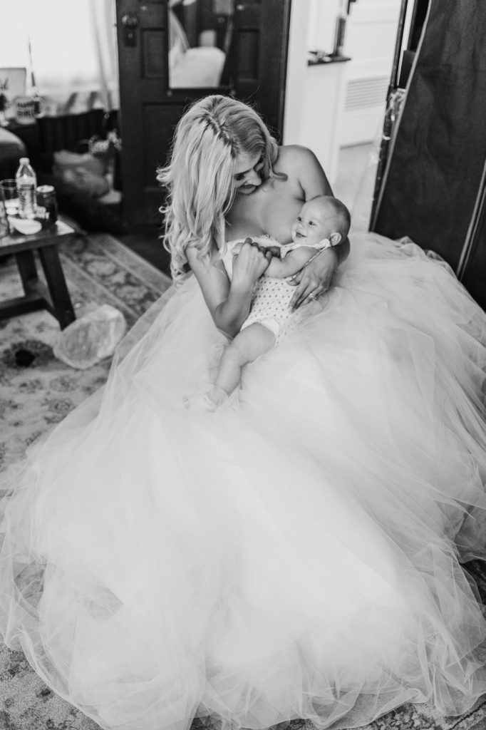 Baby takes a break from eating to smile at the bridal party