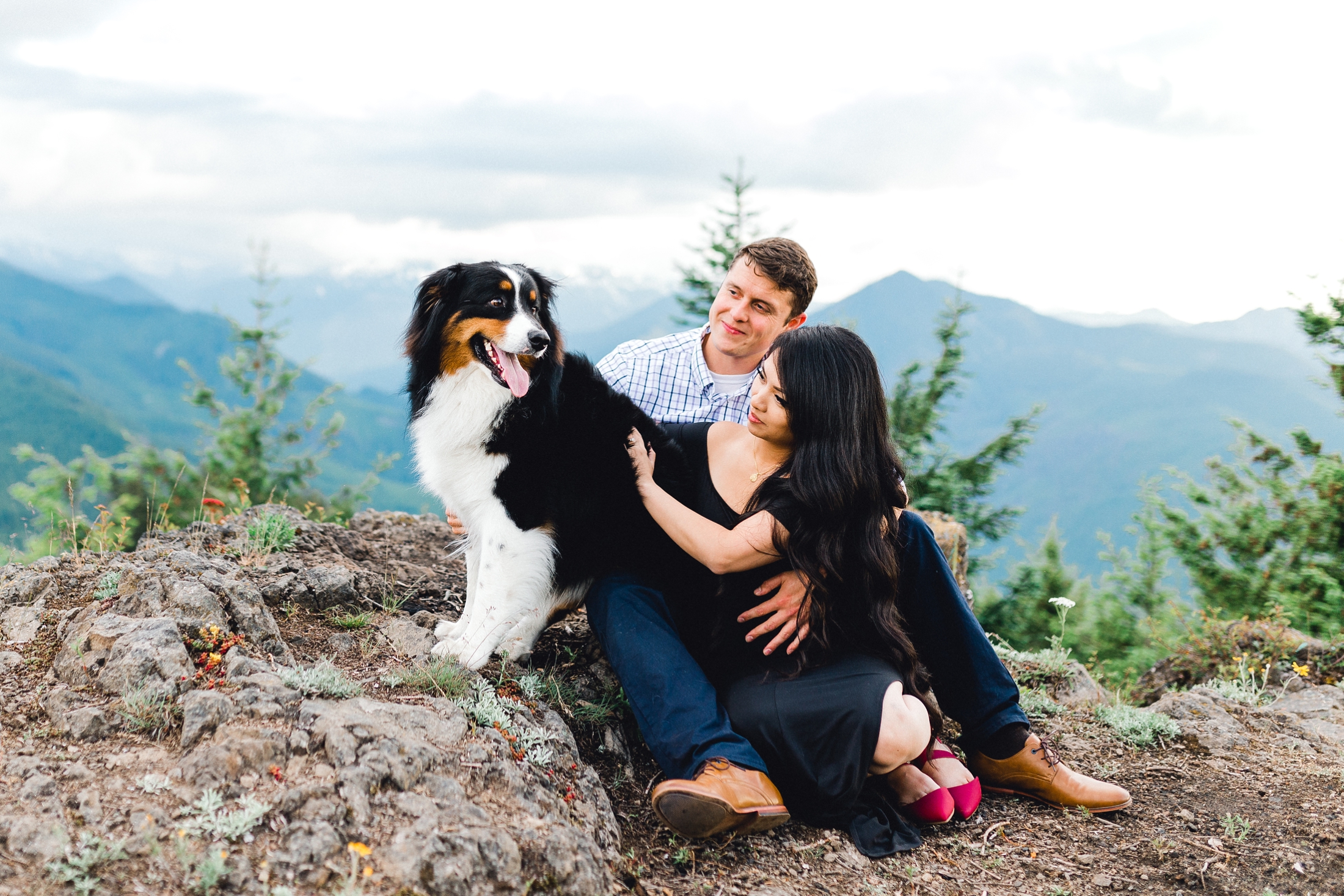 Couple sits and plays with dog.