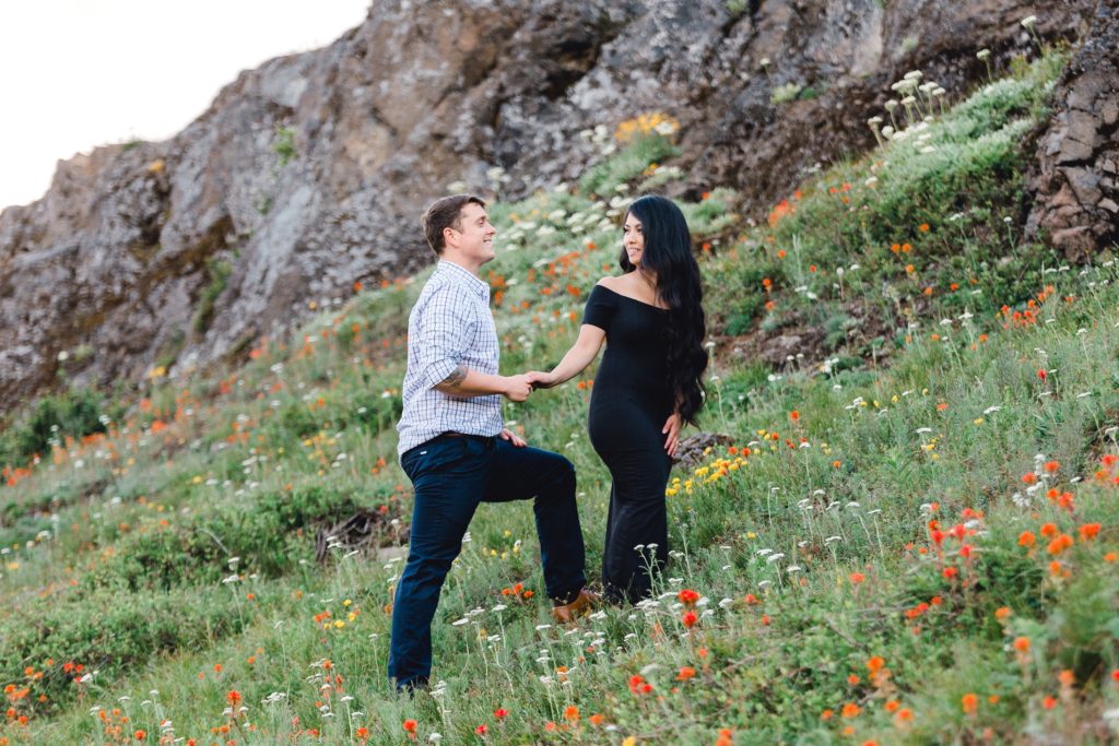 Man and woman walk through wild flowers